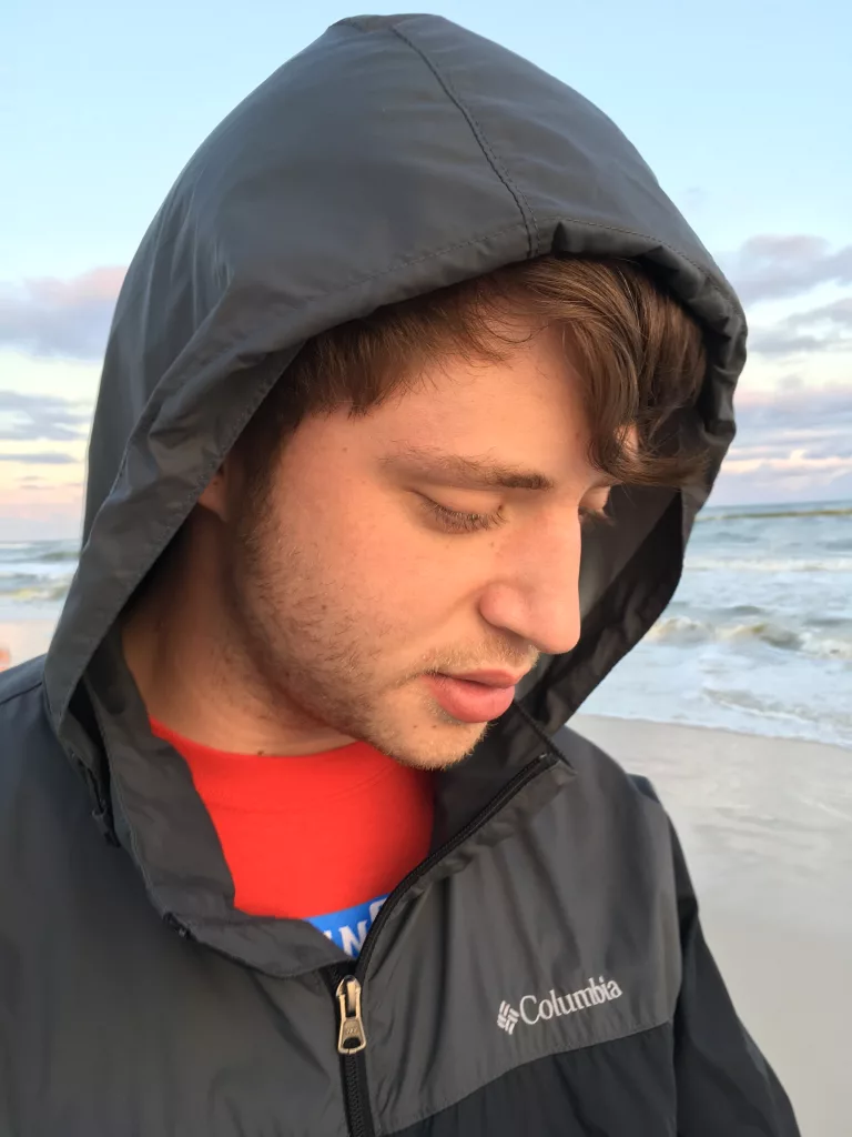 Young man in Columbia jacket at the seashore.